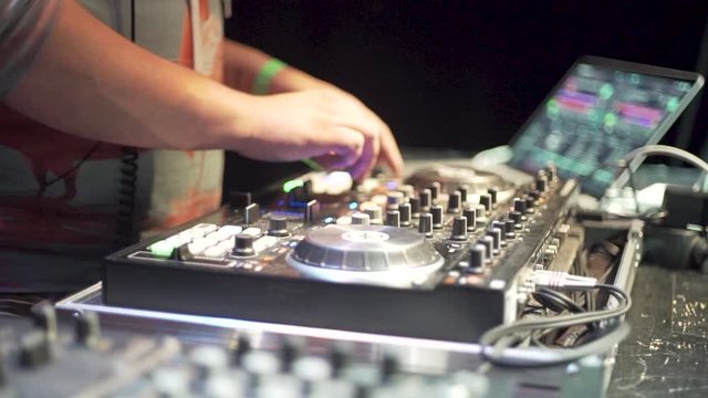 Close up of a dj using a mixer at a party in slowmotion