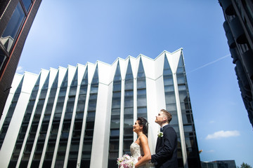 Bride and groom walking in the city, wedding day, marriage concept. Bride and groom in urban background. young couple in wedding day.