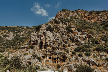 Broken Antique Construction with Old Column and Green Forest on Rocky Scree Slope Outdoor Concept. Destroyed Ancient Building of Beautiful Architecture Landscape Mountain Background.