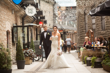 Bride and groom walking in the city, wedding day, marriage concept. Bride and groom in urban...