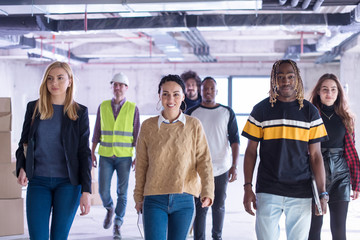 Obraz premium young multiethnic business people walking through unfinished startup office