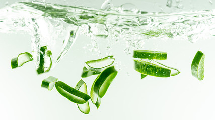 Aloe vera splashing in some water on white background