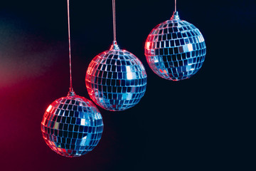 Obraz premium Sparkling disco balls hanging in the air against black background
