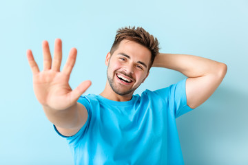 Fototapeta premium Portrait of happy young man on color background