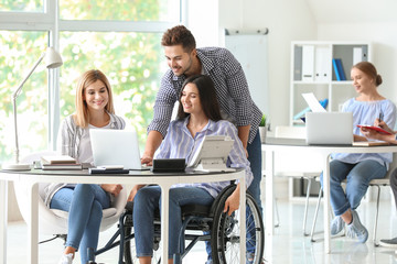Handicapped young woman with colleagues working in office
