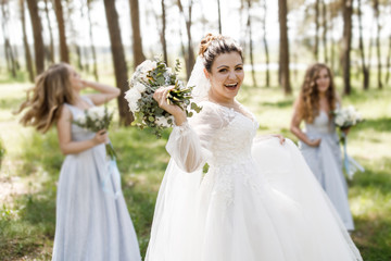 Obraz na płótnie Canvas Wedding day. The bride has fun outdoors on her wedding day with her girlfriends
