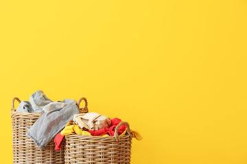 Baskets with dirty laundry on color background