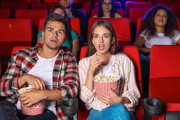 Couple with popcorn watching movie in cinema