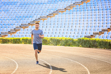 Obraz premium Sporty man running at the stadium