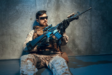 American private military contractor holding rifle. Image on a dark background