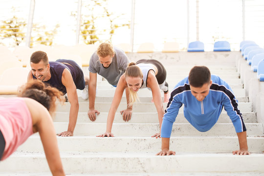 Group of sporty young people training at the stadium