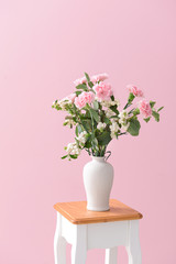 Vase with bouquet of beautiful flowers on table