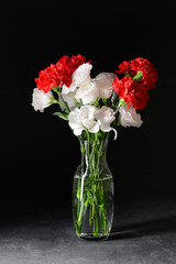Vase with beautiful flowers on dark background