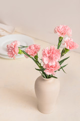 Fototapeta na wymiar Beautiful carnation flowers in vase on table