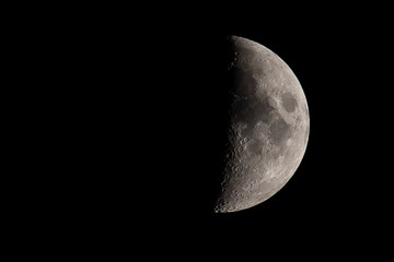 Crescent half moon, first quarter. Balck background with copy space.