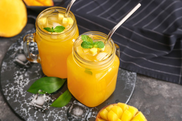 Mason jars of fresh mango juice on table