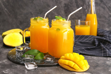 Fototapeta na wymiar Mason jars of fresh mango juice on table