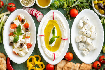 Closeup of Labneh, Greek cheese with veggies and Cheese with Fennel flower seeds and veggies;...