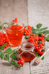 Cozy autumn winter fall photo with a hot mug of red tea on vintage wooden background, copy space. Seasonal warming beverage