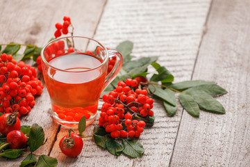 Cozy autumn winter fall photo with a hot mug of red tea on vintage wooden background, copy space. Seasonal warming beverage