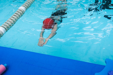 kid learn how to swim in swimming class