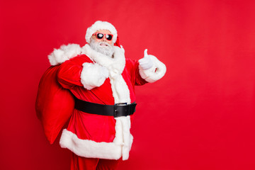 Portrait of his he cheerful cheery glad confident funky fat overweight plump gray-haired bearded man piggy backing bag showing thumbup isolated over bright vivid shine red background