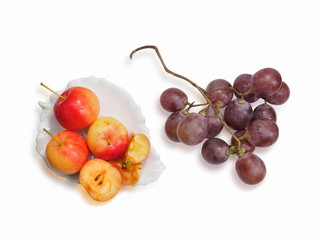 Top view of Wild Apple (Malus sylvestris) in white plate and grapes on white background.
