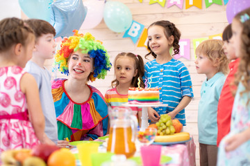 Clown playing with children. Kids group celebrate birthday party. Holiday in a children's club.