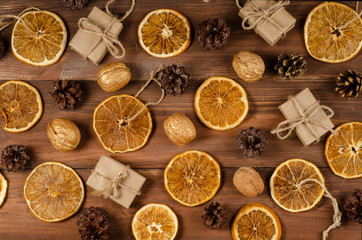 Christmas composition. Christmas pattern of dried orange, gift boxs, nuts, pine cones on wooden background. Christmas concept. Flat lay, top view