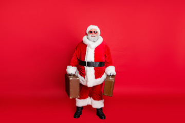Full length body size view of nice attractive cheerful cheery content fat bearded man carrying vintage bags luggage baggage ready voyage isolated on bright vivid shine red background