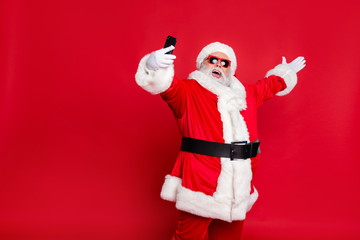 Fototapeta na wymiar Portrait of his he nice attractive cheerful cheery positive glad friendly hospitable bearded Santa pouted lips taking making selfie blog blogger isolated over bright vivid shine red background