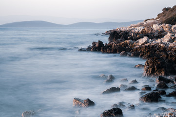 Beautiful stones, rocks and sea in a mystical haze at sunset. Long exposure. cool light landscape. Turkey. Aegean sea shore.