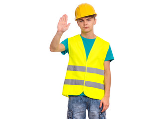 Handsome Teen Boy wearing Safety Jacket and yellow Hard Hat doing stop sign with palm of hand. Portrait of serious Child making stop gesture and Looking at camera, isolated on white background.