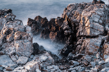 Beautiful stones, rocks and sea in a mystical haze at sunset. Long exposure. cool light landscape. Turkey. Aegean sea shore.
