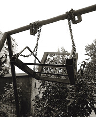 Old broken swing in black and white colors in the city