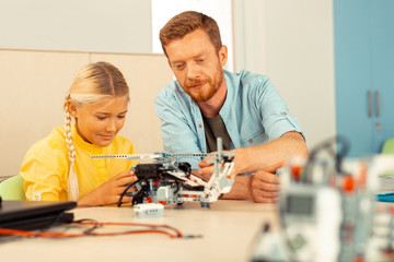 Teacher and pupil building a helicopter together.