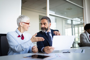 Portrait of happy business people discussing together in office
