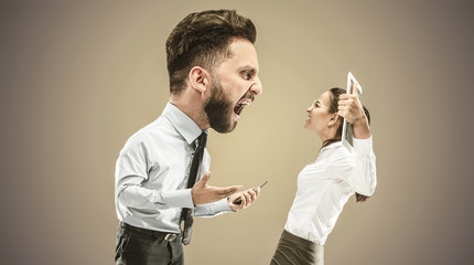 Angry businessman screaming at employee in the office. Caucasian woman is under the pressure and...