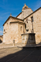 Well in front of San Quirico church at sunny morning in San Quirico d'Orcia , Siena province, Tuscany, Italy
