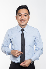 Asian businessman holding his neck tie