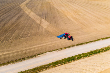Obraz na płótnie Canvas Big tractor ploughing dry soil in rural area. Precipitation problem
