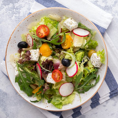 Diet salad with fresh vegetables, lettuce, arugula and cheese. Top view. Closeup