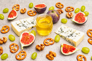Cheese appetizer selection or wine snack set. Blue cheese, figs, honey, walnuts, pretzels