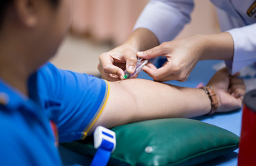 Thailand, Bangkok 2019/08/28. A health worker taking a blood sample from the vein by piercing the...