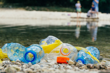 PLASTIC POLLUTION in the river. Dirty plastic bottles and bags on a garbage. River pollution, plastic in water. Pollution and recycle eco concept.