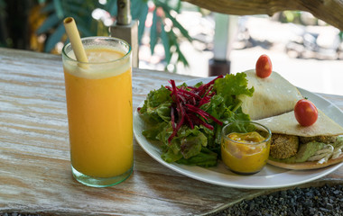 Vegan tortilla wrap, with vegetabes on a wooden background