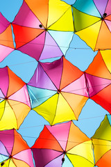 Colorful umbrellas background in blue clear sky. Creative street decoration.