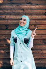 Portrait of pretty young muslim woman on a street.