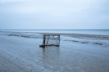 Fototapeta na wymiar Abandoned football net on the winter beach.