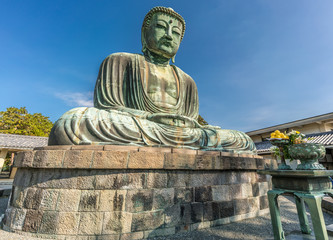 Obraz premium Monumental outdoor bronze statue The Great Buddha in Kamakura, Japan. Wide angle view with clear blue sky